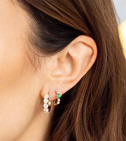 Diamond huggie earrings styled in multiple piercings