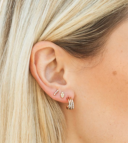 Minimal stud earrings styled in stacked piercings