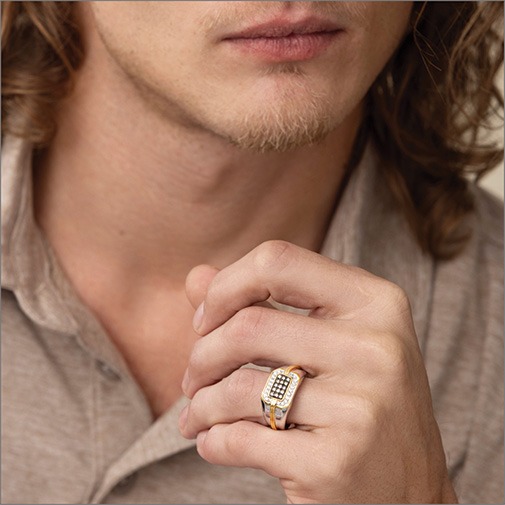 Close up of man wearing a two-tone ring with champagne diamonds
