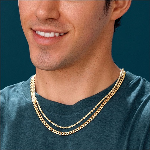 Close up of man wearing a yellow gold rope chain and yellow gold cuban chain