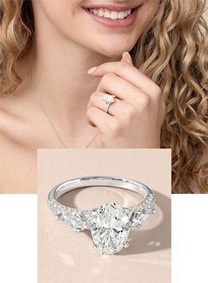 Woman wearing a Downton Abbey inspired engagement ring and a vintage-inspired oval diamond engagement ring from the Downton Abbey collection