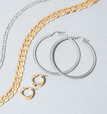 Gold and sterling silver chain necklaces and hoop earrings representing the value of selling unwanted jewelry to REEDS Jewelers