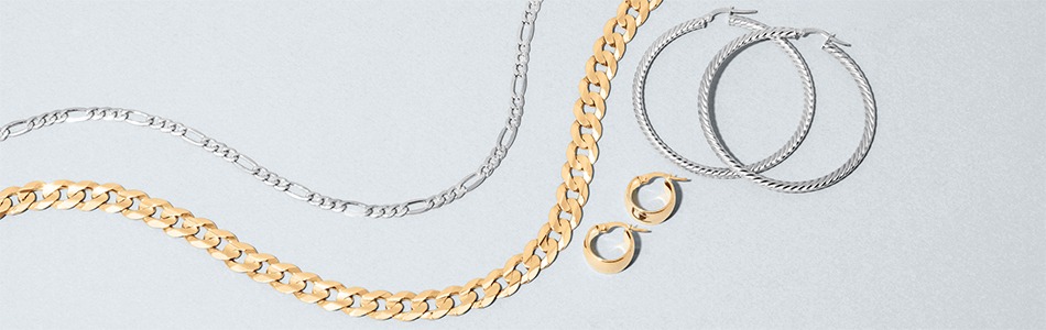 Gold and sterling silver chain necklaces and hoop earrings representing the value of selling unwanted jewelry to REEDS Jewelers