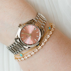 Rose tone dial watch with layered bracelets for cool toned skin