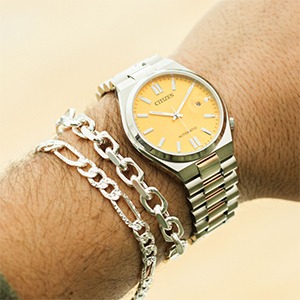 Yellow dial watch with silver bracelet styling for warm toned complexions